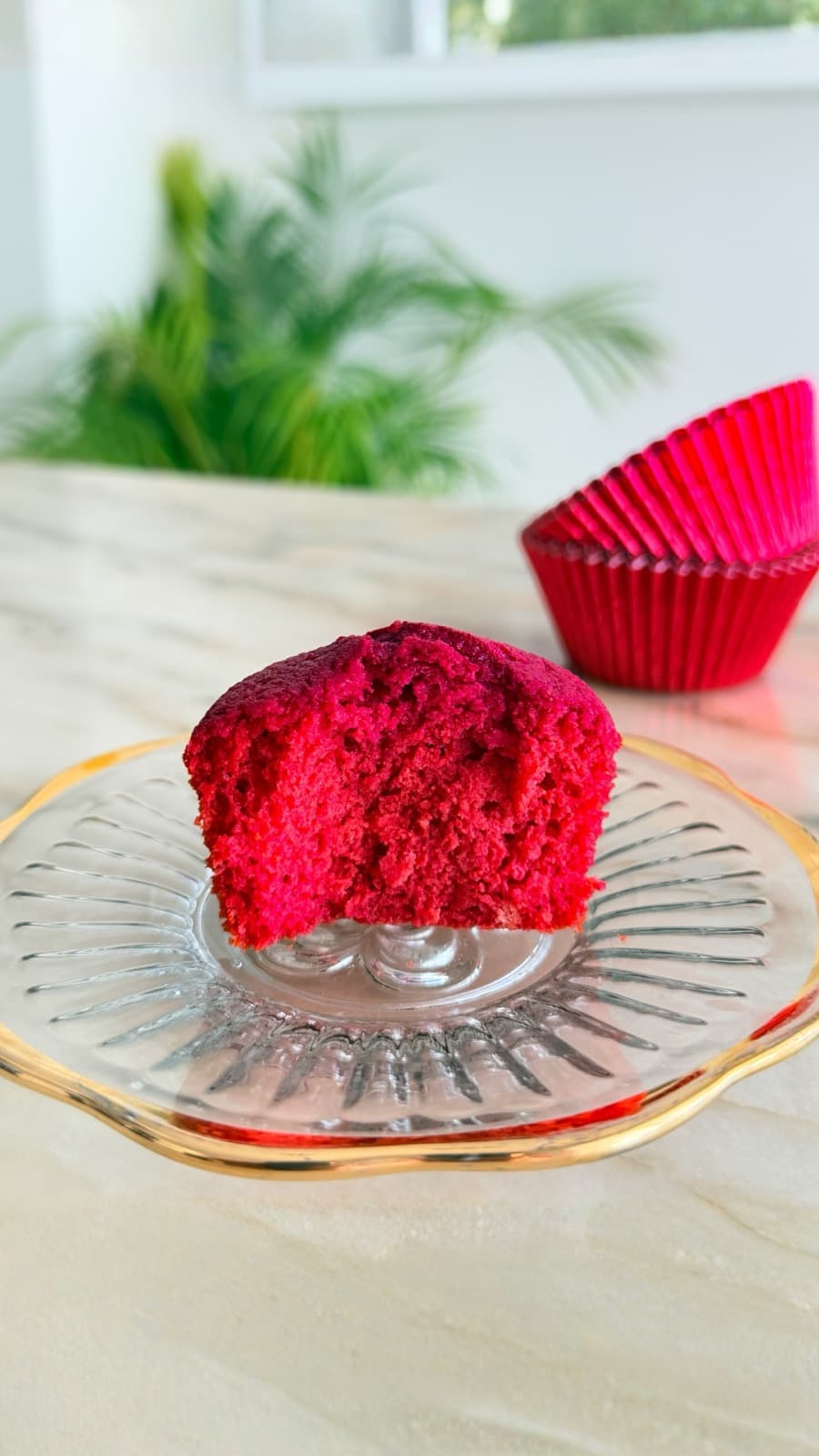 A red velvet cupcake on a glass stand