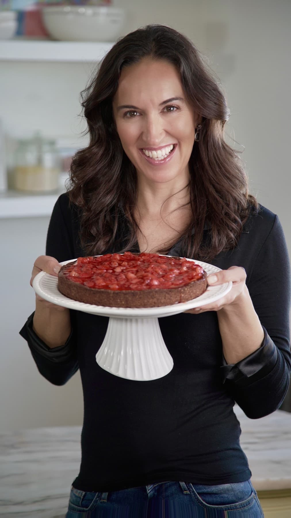 Leonor holding a raspberry cake made without gluten, dairy or refined sugar
